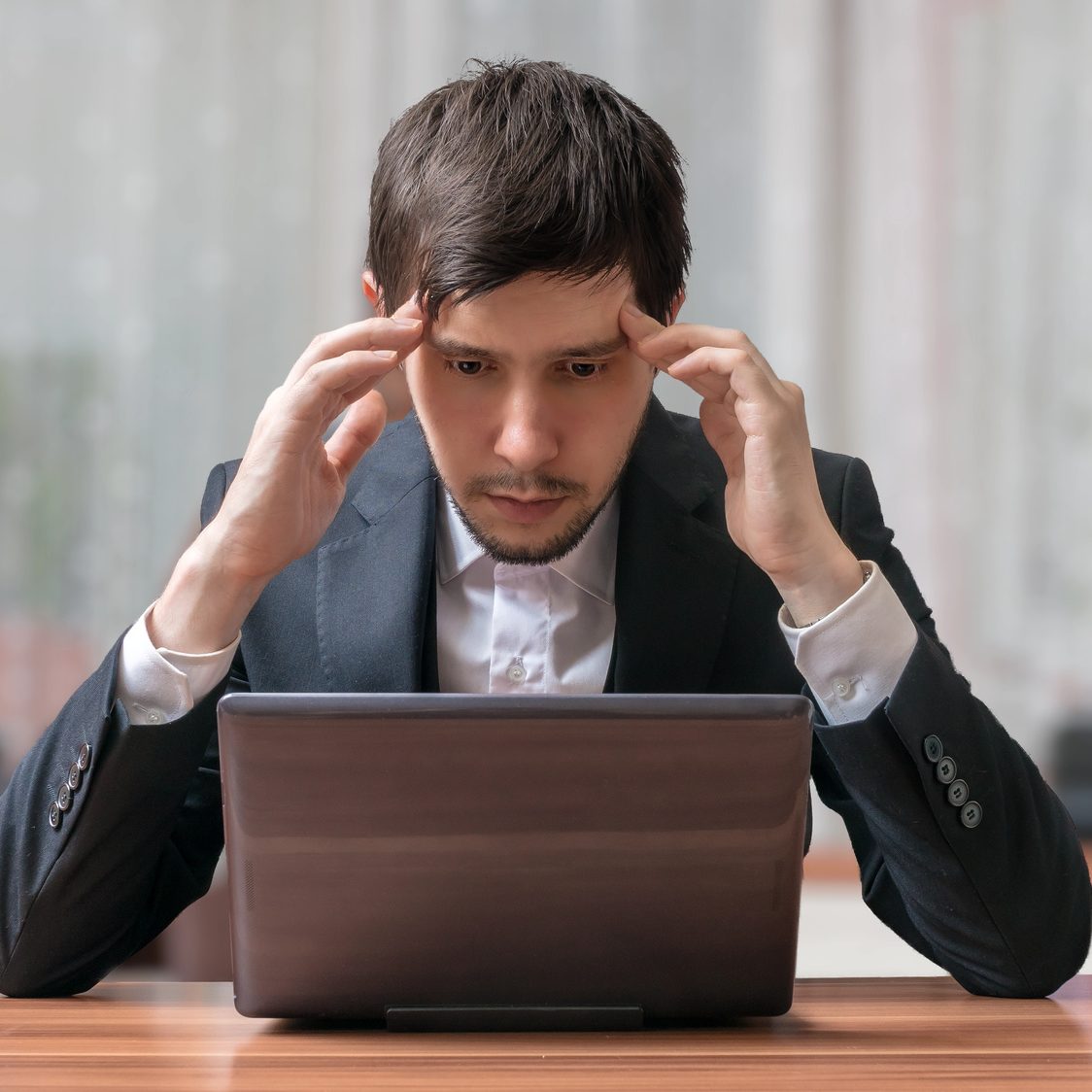 Young intend and thinking businessman working with laptop.
