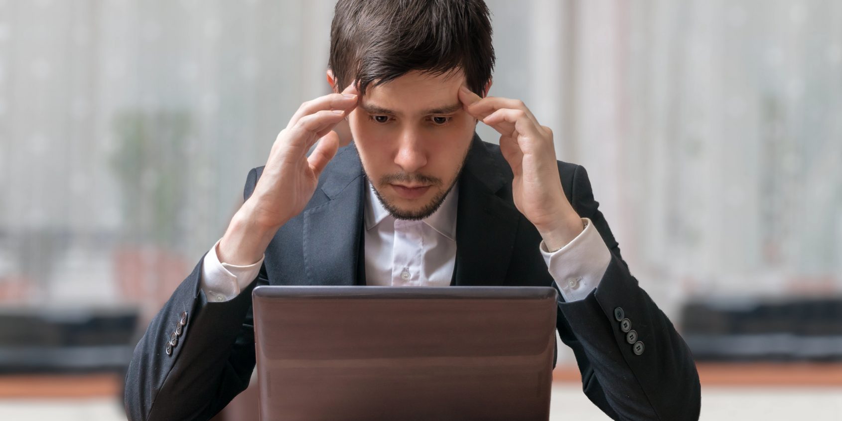 Young intend and thinking businessman working with laptop.