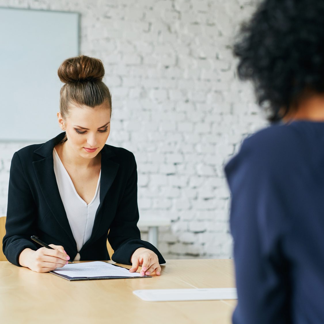 Job interview – young woman signing employment contract