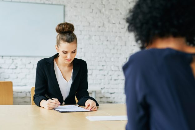 Job interview – young woman signing employment contract